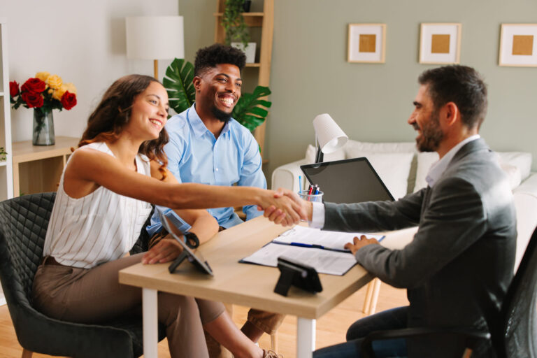 Una pareja sellando un acuerdo con un broker hipotecario