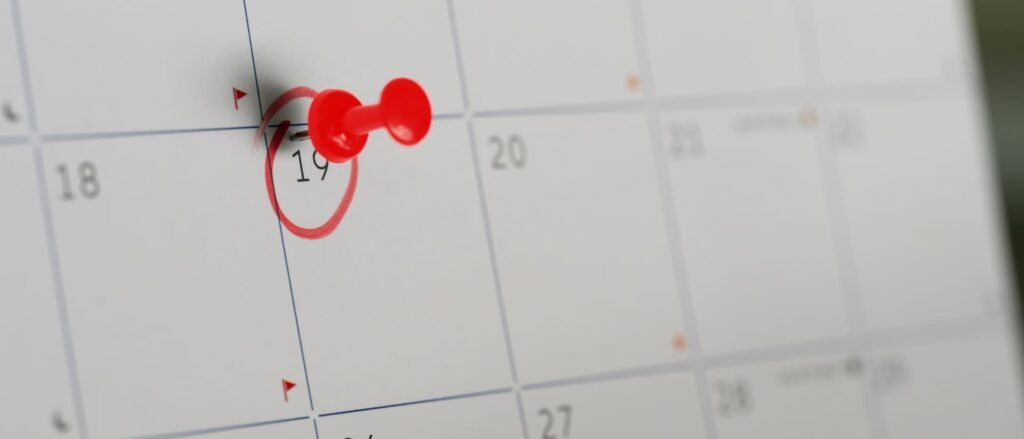 un calendario con un día marcado en rojo y con una chincheta