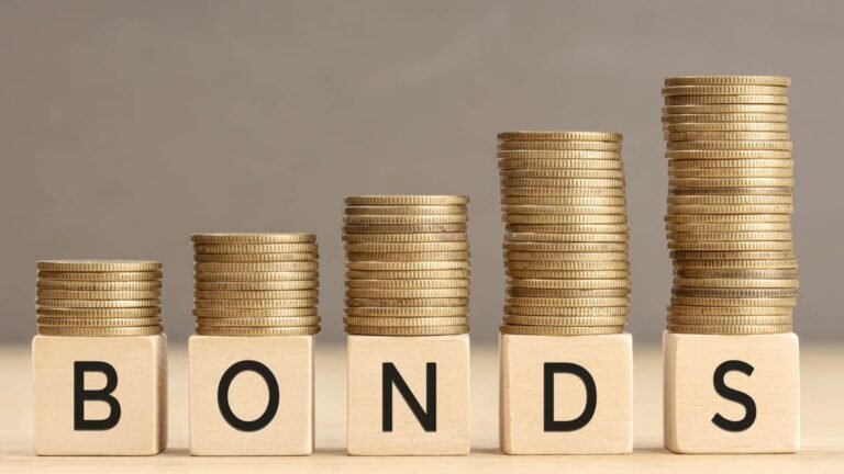 bonos escrito en inglés en bloques de madera con montones de monedas encima