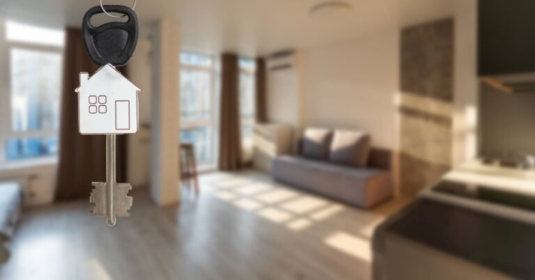Las llaves de una vivienda sobre un fondo desenfocado que muestra la vivienda