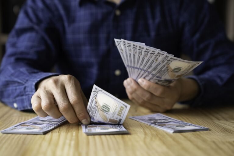 Un hombre organizando billetes en diferentes montones