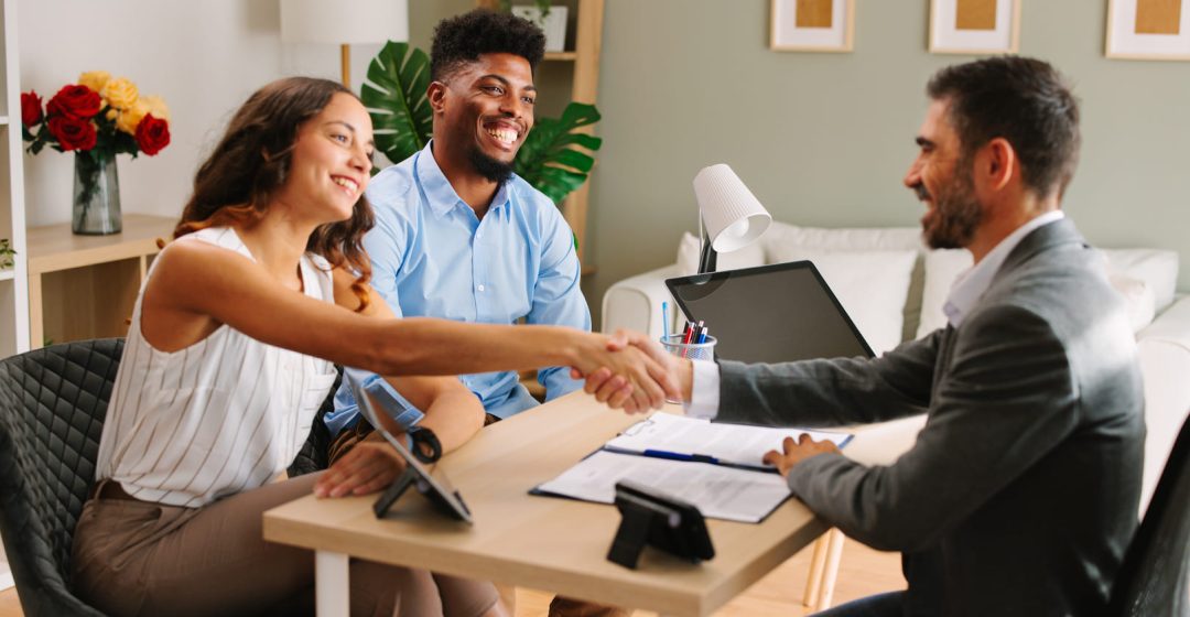 Una pareja sellando un acuerdo con un broker hipotecario