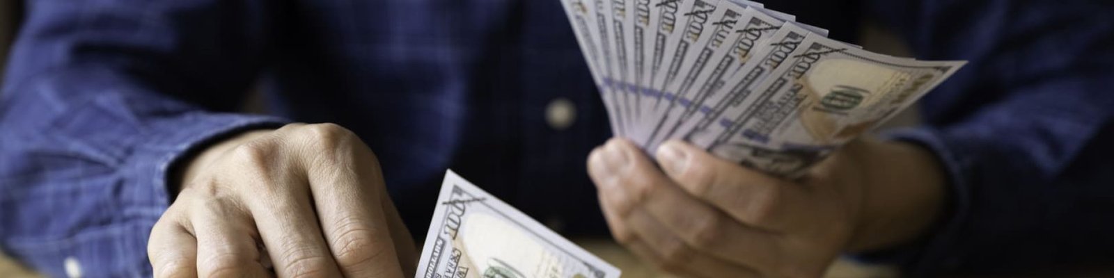 Un hombre organizando billetes en diferentes montones