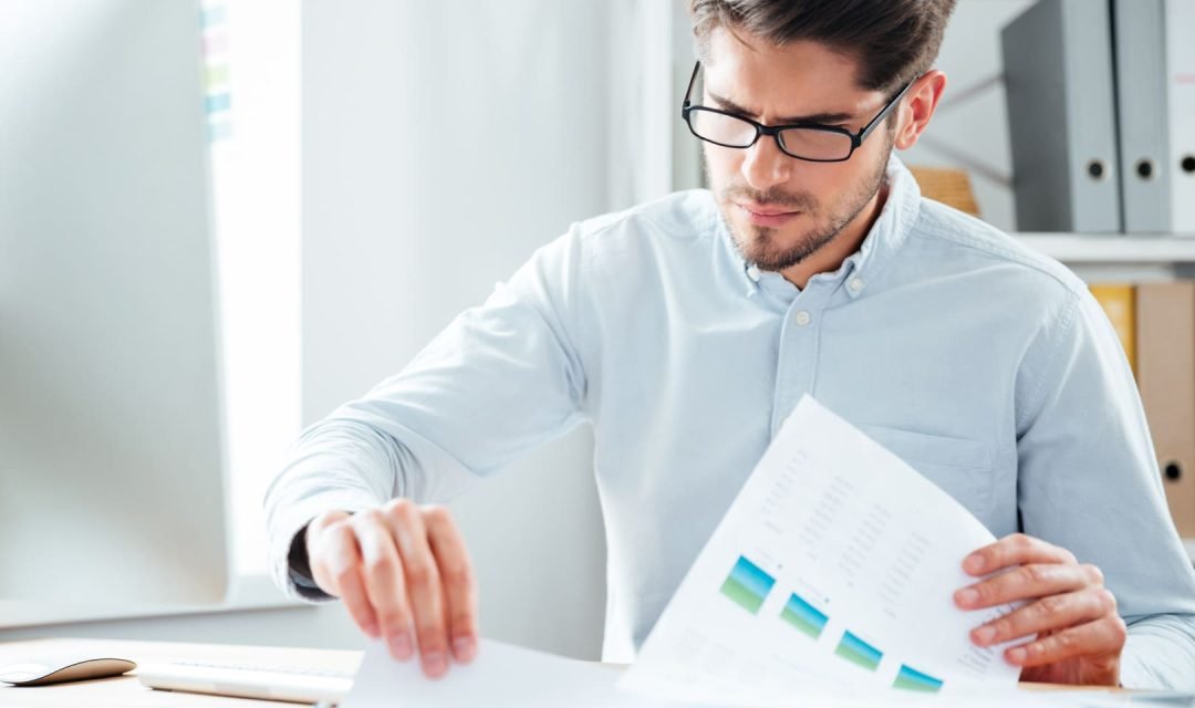 un hombre mirando documentos y comparando
