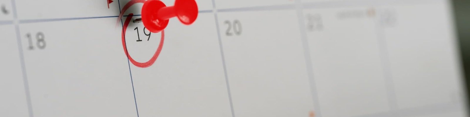 un calendario con un día marcado en rojo y con una chincheta
