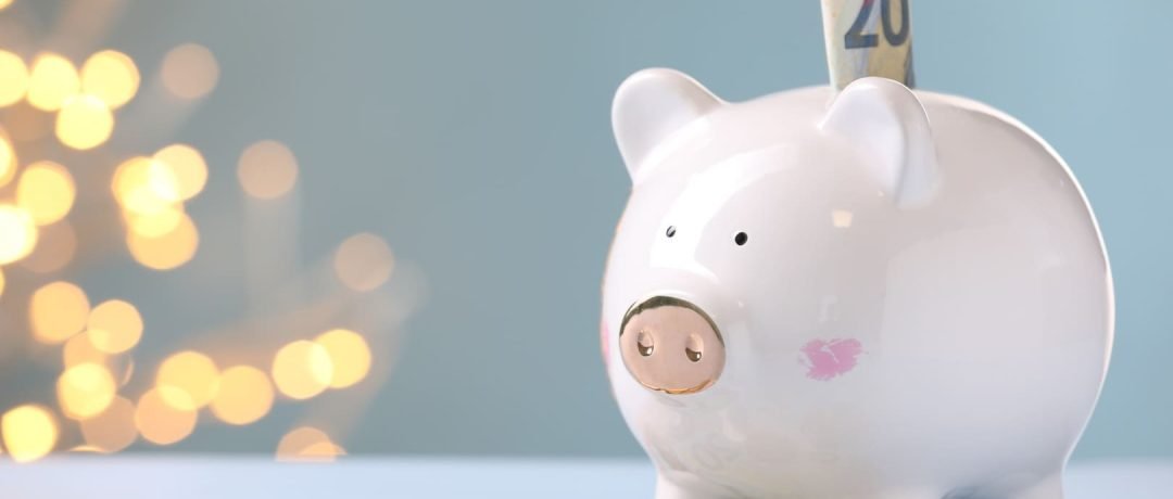 Hucha en forma de cerdito con euros alrededor