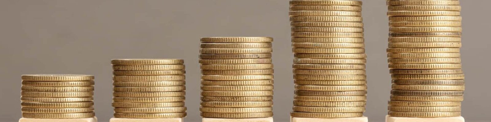 bonos escrito en inglés en bloques de madera con montones de monedas encima