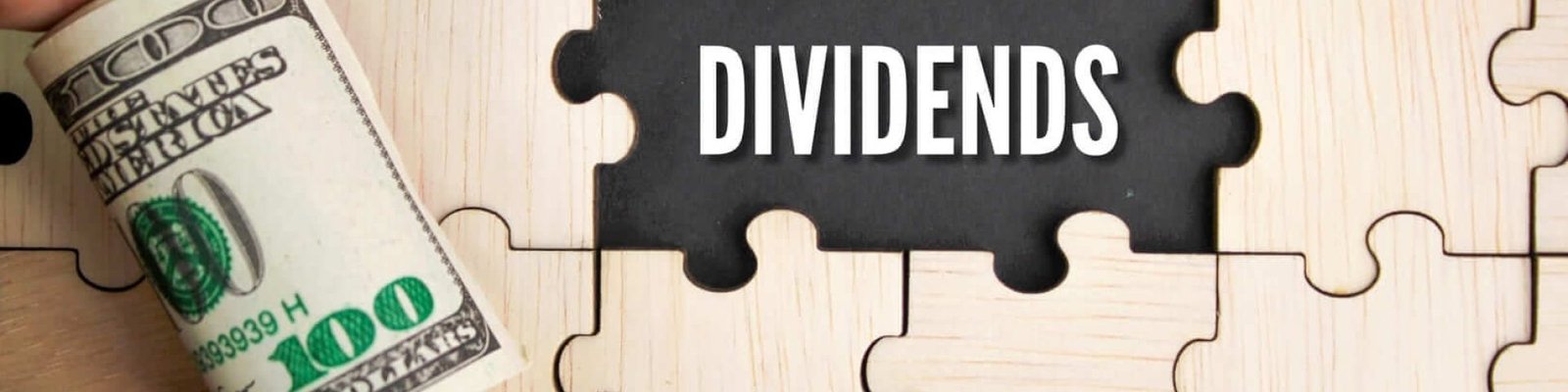 una mano con un fajo de billetes y la palabra dividendos en inglés