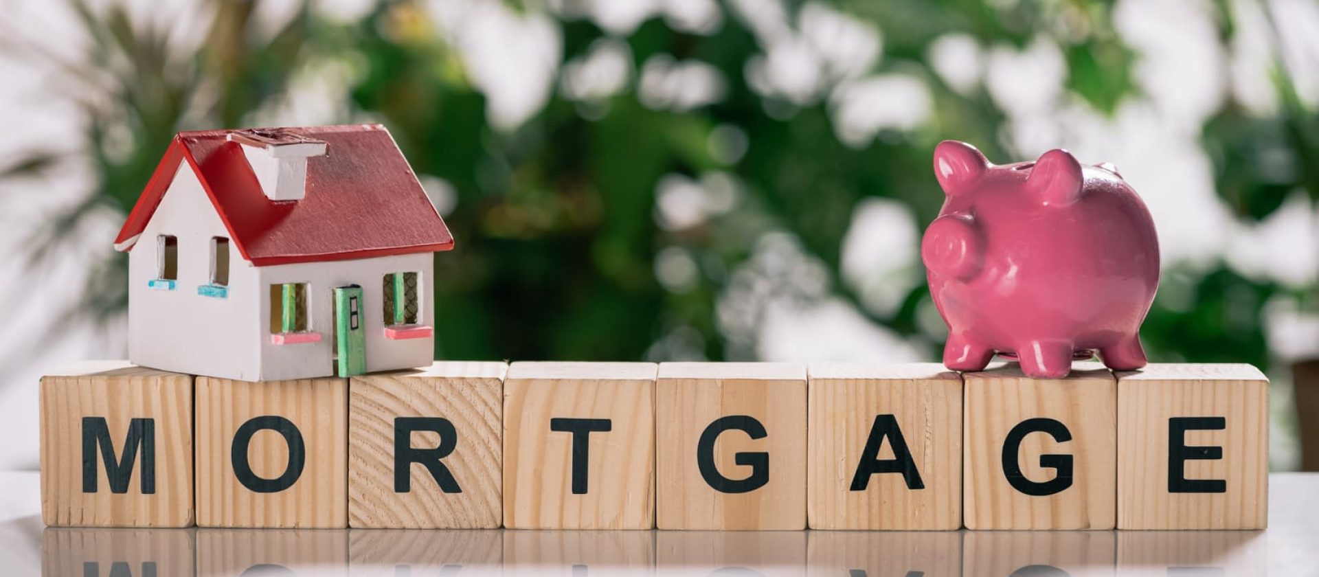 Una casita de juguete y bloques de letras que dicen hipoteca